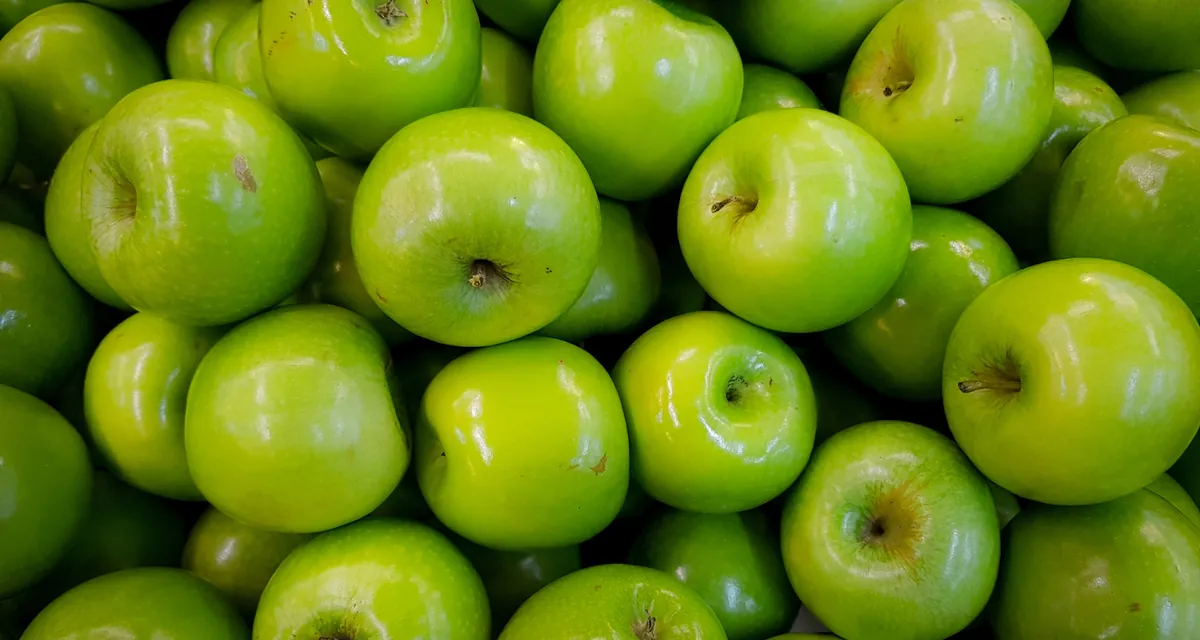Maçãs verdes empilhadas em close