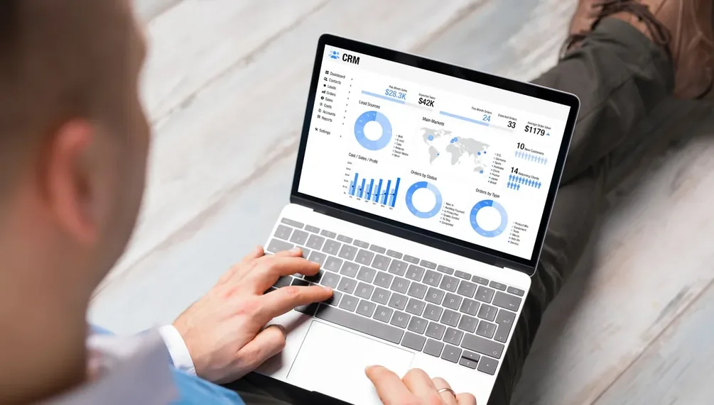 Mãos operando notebook que exibe gráficos de desempenho